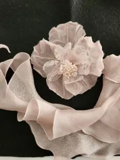 淡いピンクの花ブローチとリボン