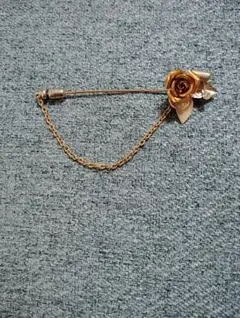 バラの形状の金色ブローチ