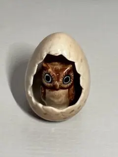 卵から顔を出すフクロウの置物のサムネイル