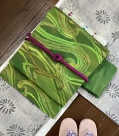 鮮やかなグリーンのグラデーションに大胆な流線文様が目を惹く膨れ織り九寸名古屋帯