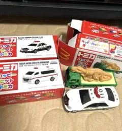 ハッピーセットトミカトヨタクラウンパトロールカー2つ、日産NV救急車、恐竜搬送車