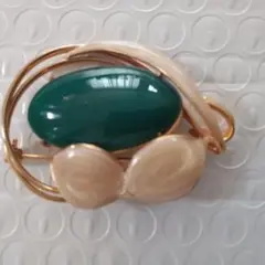 緑色の樹脂と金属製の抽象的なデザインのブローチ。 緑色とベージュのブローチ