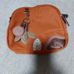 オレンジ色のショルダーバッグ 花の装飾付き