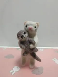 カワウソのぬいぐるみを抱っこしているフェレット羊毛フェルトぬいぐるみ
