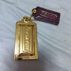 COACH ゴールドロゴチャームとブラウンレザーチャーム