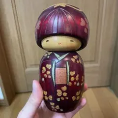 伝統的な木製こけし 赤色金色模様