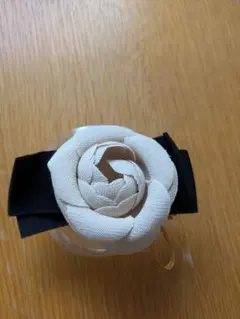 ベージュのバラ形コサージュ 黒リボン付き