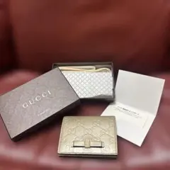 GUCCI グッチ 二つ折り財布 シマ リボン ゴールドのサムネイル