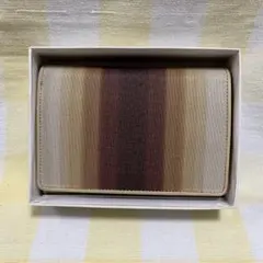 ブラウンのグラデーションが特徴な、ナイロンと牛革を使用したコンパクト二つ折り財布