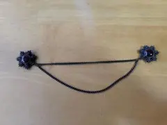 ワインレッドの金属製の花形ブローチ