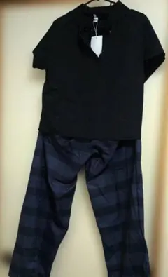 黒のVネック半袖トップスとストライプパンツセットアップ
