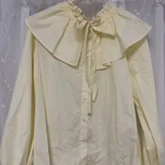 淡い黄色のフリル付き長袖シャツ