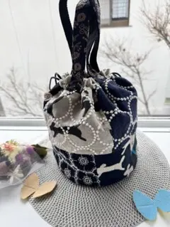 ミナペルホネン 片側パッチの丸底巾着バッグ