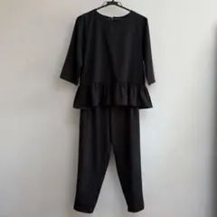 黒のペプラムトップスとパンツセットアップ