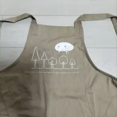 ベージュのロングエプロン 木とキャラクタープリント