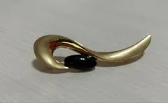流線型デザインの金色と黒のブローチ