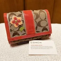 新品未使用]COACHコーチ二つ折り財布 シグネチャー 花柄 リボン ピンク