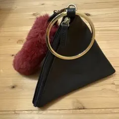 黒の三角形ハンドバッグとファー付きキーチェーンのサムネイル