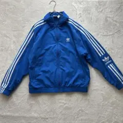 アディダスオリジナルズ　トレフォイル刺繍入り青ナイロンジャケット 3本ライン　M