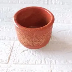 オレンジ色の陶器製茶碗