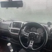 身の丈に合う車に乗る男の画像